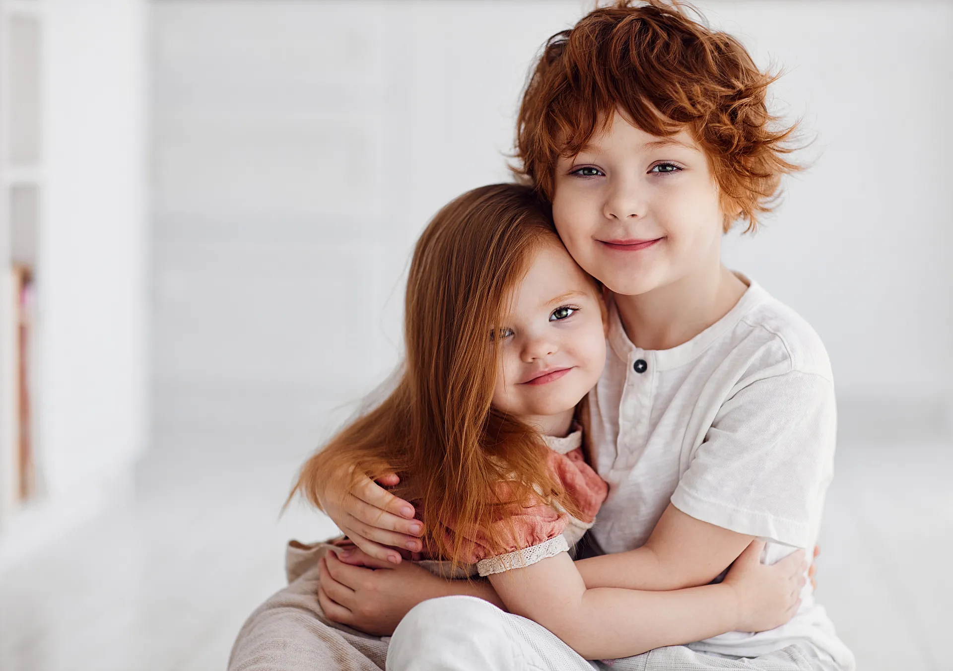 Zwei rothaarige Kinder umarmen sich