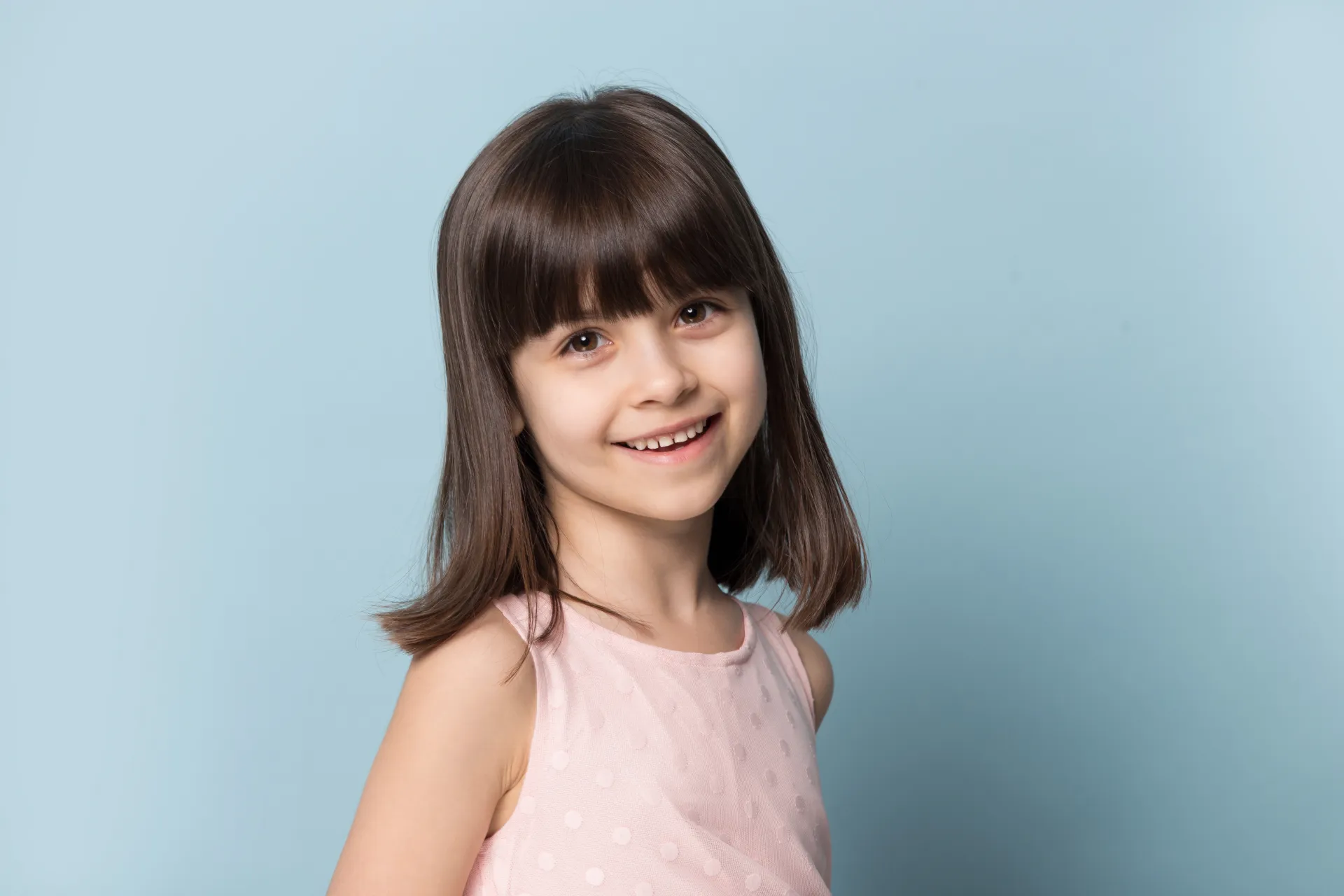 Laechelndes Maedchen mit braunen Haaren