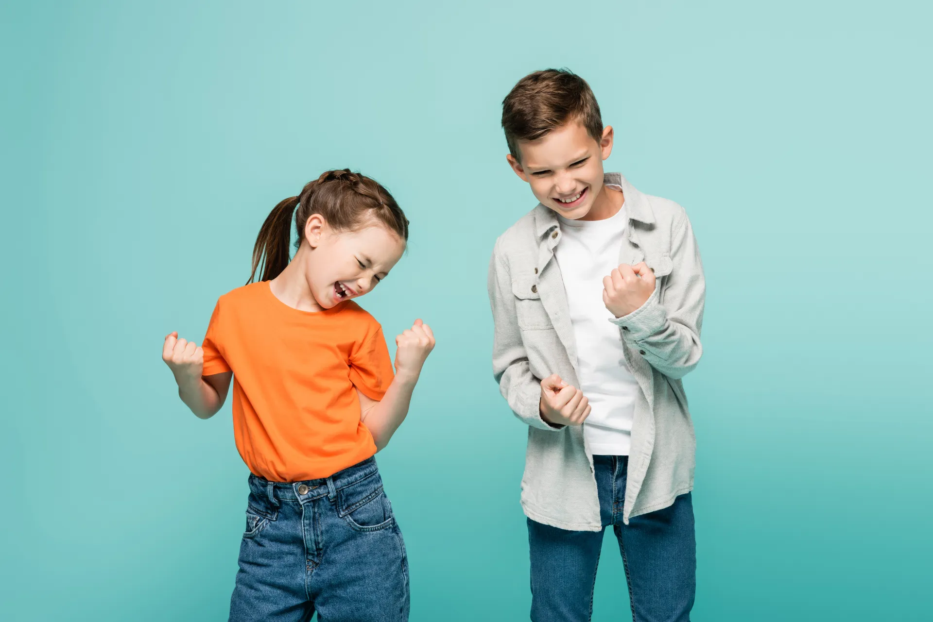 Zwei jubelnde Kinder vor blauem Hintergrund